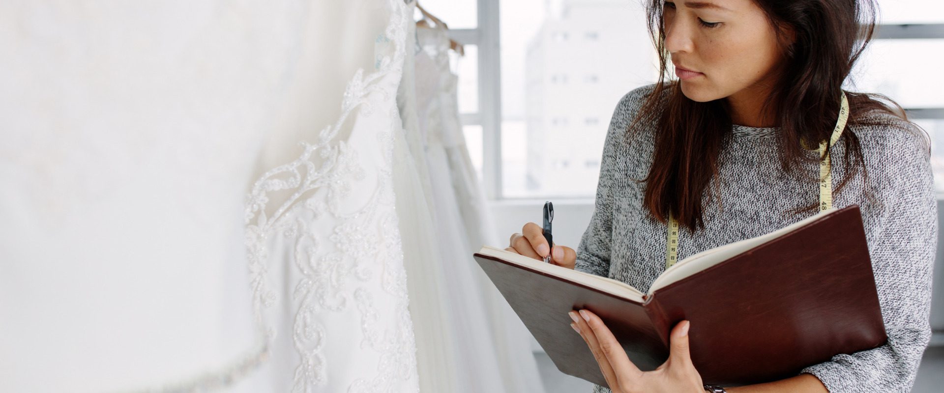 bridal store employee taking inventory in notebook