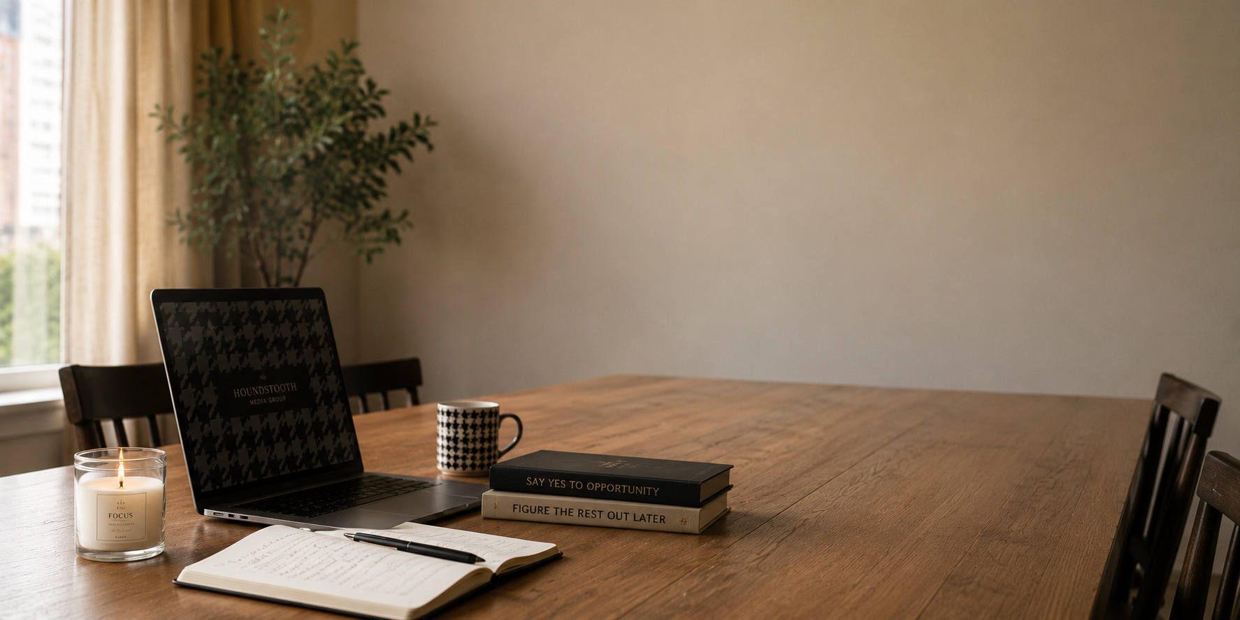 Minimalist home office with a wooden desk, laptop, notebooks, and a coffee mug in a bright workspace.